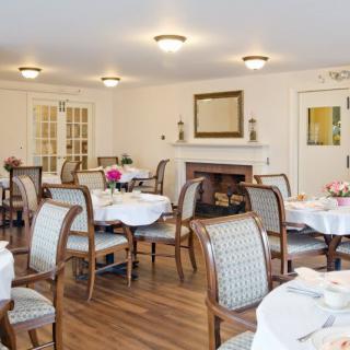 A well-decorated dining room featuring elegant tables and chairs set for a meal.