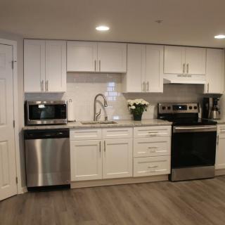 A modern kitchen with white cabinets and stainless steel appliances.