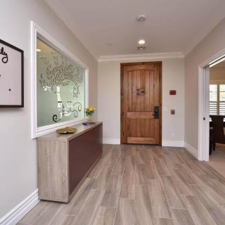 A modern hallway with wooden flooring and minimalistic decor leading to a wooden door.