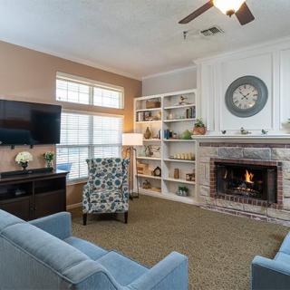 A cozy living room featuring a fireplace, comfortable sofas, and a large TV.