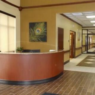 A reception desk in an office lobby with a hallway leading to other rooms.