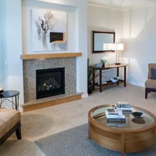 A modern living room featuring a fireplace, comfy seating, and a stylish coffee table.