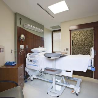 A modern hospital room with a medical bed and equipment.