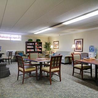 A cozy lounge with comfortable seating, bookshelves, and warm lighting.