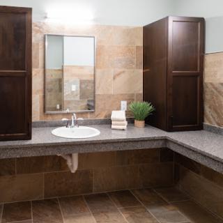 A modern bathroom showcasing a clean sink area with wooden cabinets and natural decor.