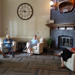 A group of people sitting in a cozy living room with a fireplace.