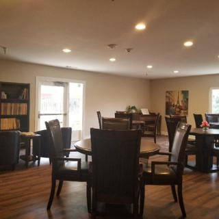 A cozy reading room with tables and chairs arranged for group activities or quiet study.