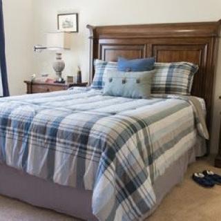 A neatly made bed with plaid bedding and decorative pillows in a cozy bedroom.
