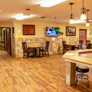A cozy dining area featuring wooden flooring and a television.
