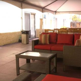 An outdoor patio with comfortable seating, including a sofa and table.