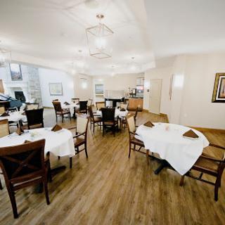 A spacious and elegantly designed dining area, featuring neatly arranged tables and comfortable seating.