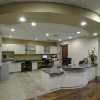 A modern office reception area featuring a curved desk and multiple computer workstations.