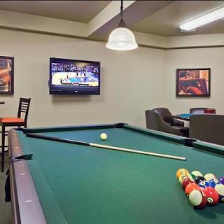 A cozy game room featuring a pool table and a television, perfect for relaxation and entertainment.