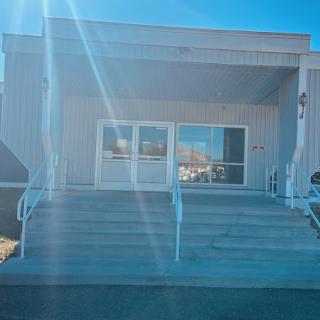 A modern building entrance with steps leading up to the glass doors.