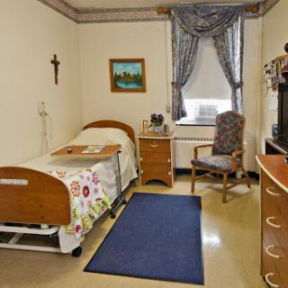 A well-organized hospital room featuring a patient bed, a chair, and decorative elements.