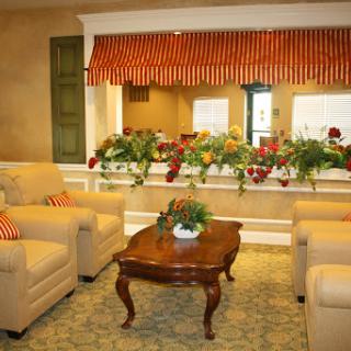 A cozy living room featuring comfortable seating, a wooden coffee table, and vibrant floral decorations.