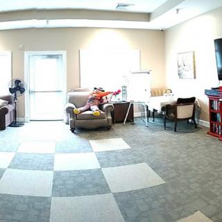 A bright living room with modern furniture, including sofas, chairs, and a television.