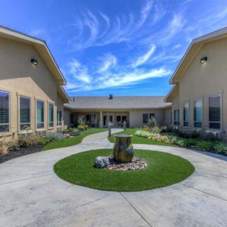 A modern courtyard with landscaped gardens and a clear blue sky.