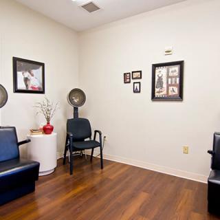 A cozy waiting area in a hair salon with chairs and decorative wall art.