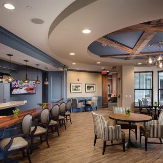 A modern interior featuring a kitchen and dining area with elegant seating and wood flooring.