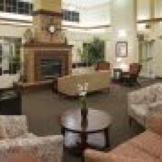 A cozy lobby with comfortable seating and a central fireplace.