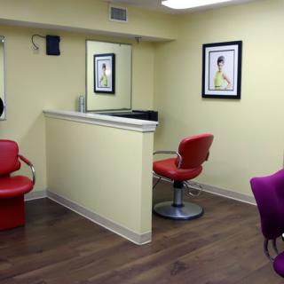 A modern hair salon interior with colorful chairs and wall art.