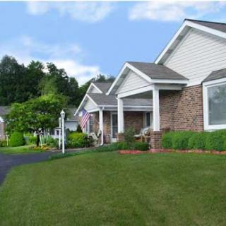 A serene view of suburban houses with lush green lawns under a clear blue sky.