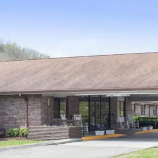 A single-story brick building with a covered entrance and paved driveway.