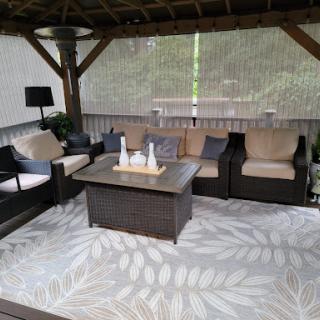 A cozy outdoor seating area featuring comfortable furniture under a gazebo.