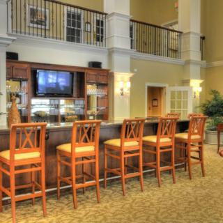 A cozy bar area with wooden chairs and a television in a well-decorated lobby.