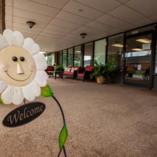A welcoming entrance with a cheerful flower decoration and outdoor seating.
