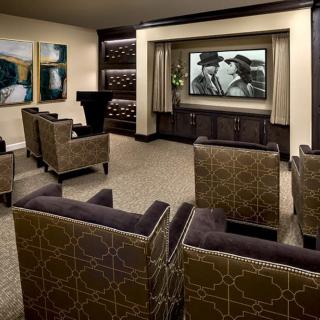 A luxurious home theater with elegant seating and artwork on the walls.