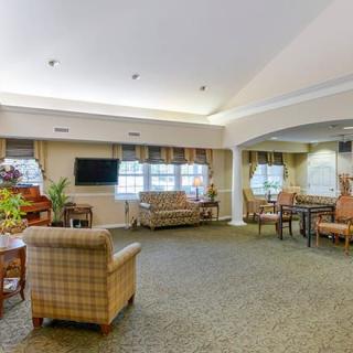 A cozy living room with comfortable seating, a television, and decorative plants.