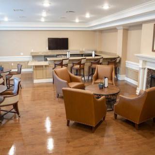 A modern lounge area with comfortable seating, a television, and a fireplace.