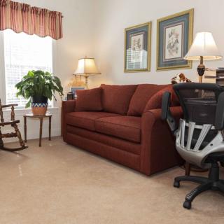 A cozy living room with a brown sofa, an armchair, and decorative elements.
