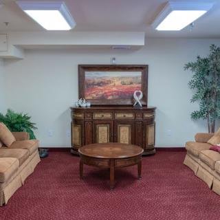 A cozy living room arrangement with two sofas facing each other, a round coffee table in the center, and decorative artwork on the wall.