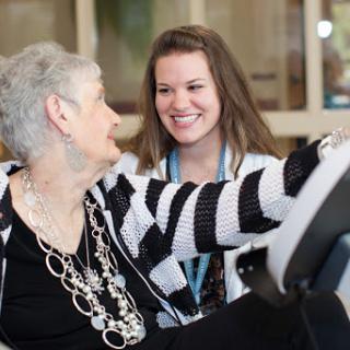 A warm moment between a caregiver and an elderly resident, sharing smiles and companionship.