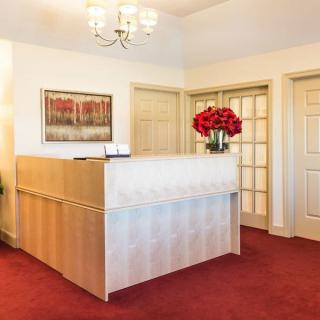 A welcoming reception area with a desk adorned with flowers and artwork on the wall.