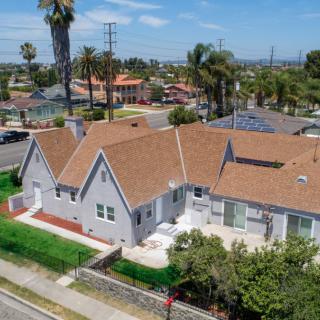 Aerial view of a suburban house with a brown roof and green yard.