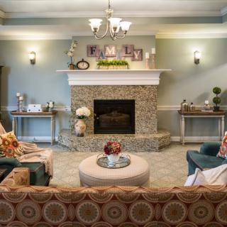 A cozy and elegantly decorated living room featuring a central fireplace, comfortable seating, and ambient lighting.