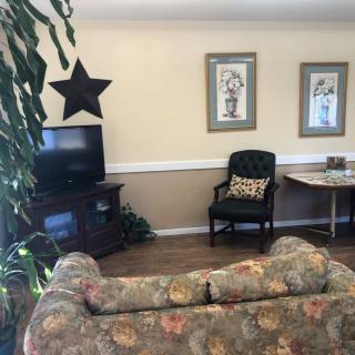 A cozy living room with a floral sofa, television, and decorative elements.