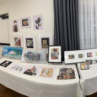 A collection of artworks and photographs displayed in an indoor gallery setting.