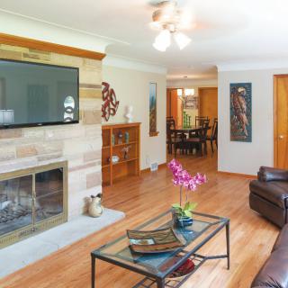 A cozy living room featuring wood flooring, a fireplace, and modern decor.