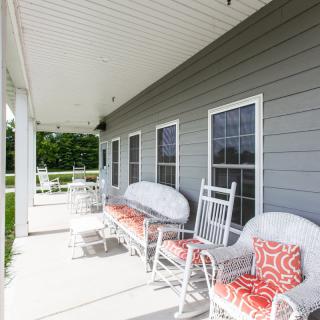 A welcoming porch with rocking chairs and colorful pillows, perfect for relaxation.