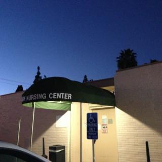 A building entrance with an awning and lights illuminated at night.