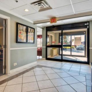 A well-lit lobby with tiled flooring and glass entrance doors.