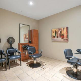 Interior of a hair salon with chairs, mirrors, and hair dryers.