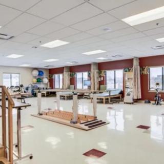 A spacious rehabilitation center equipped with therapy equipment and exercise areas.