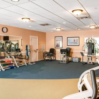 A spacious gym with various exercise equipment and a clean interior.