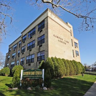 A well-maintained institutional building surrounded by greenery and signage.